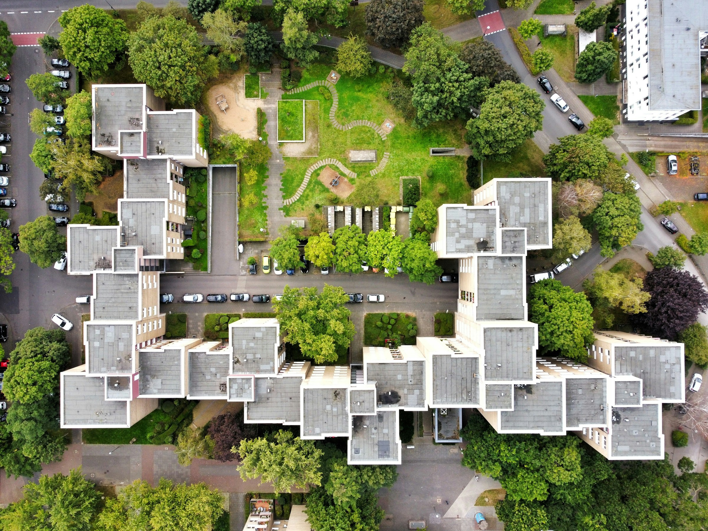 Aerial view of a modern residential apartment estate with green courtyards